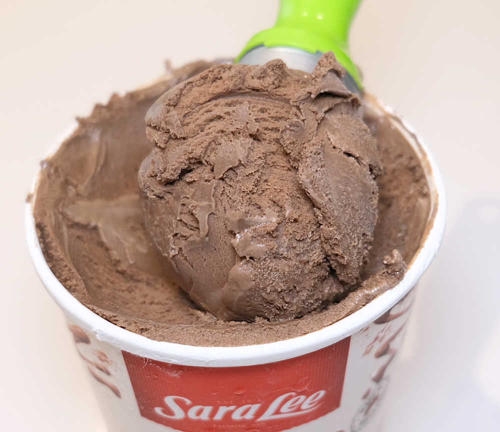 A scoop of Sara Lee Chocolate Ice Cream resting on the pack.