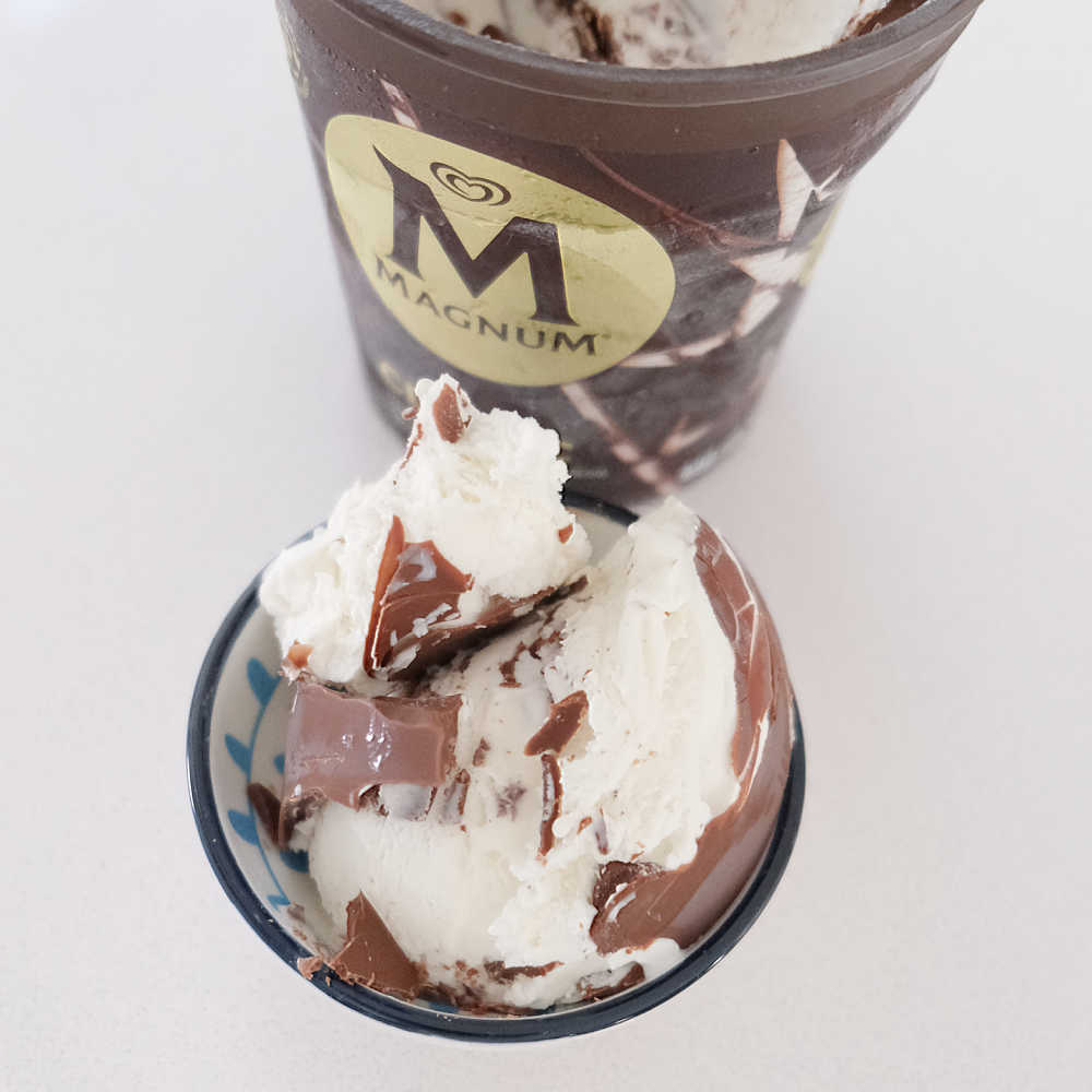 Aerial image of a Magnum classic container and a bowl scooped with ice cream.