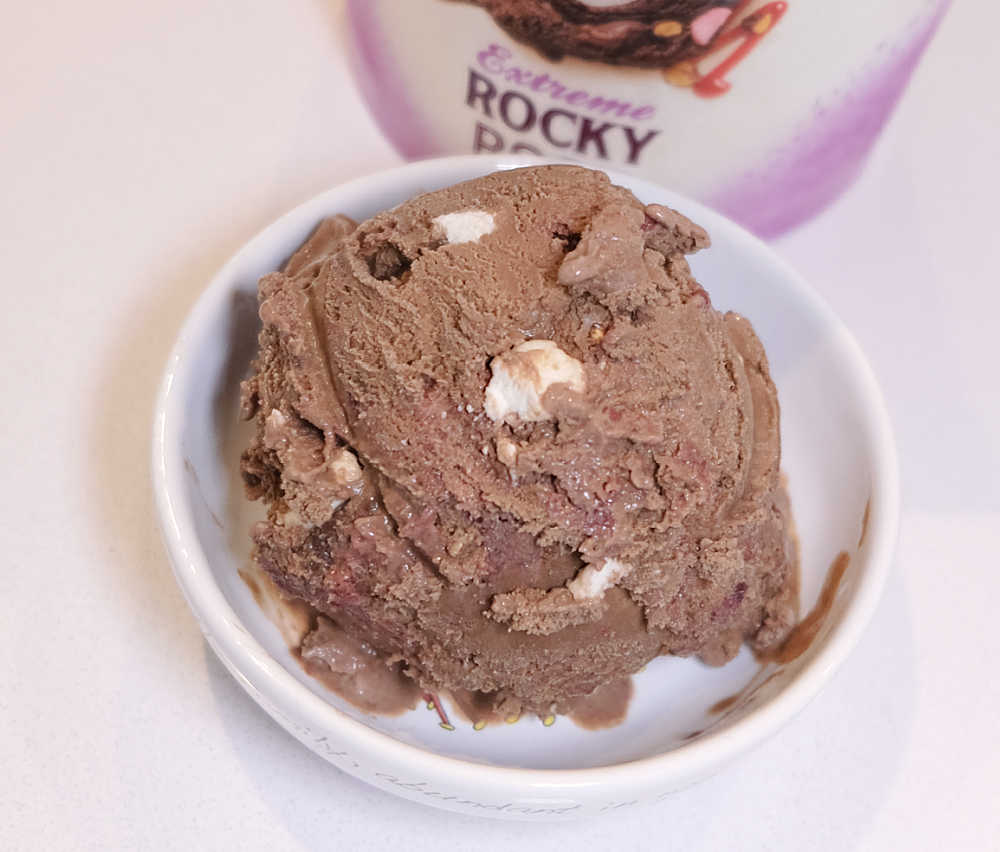 A white bowl containing Sara Lee Rocky Road Ice Cream next to the pack.