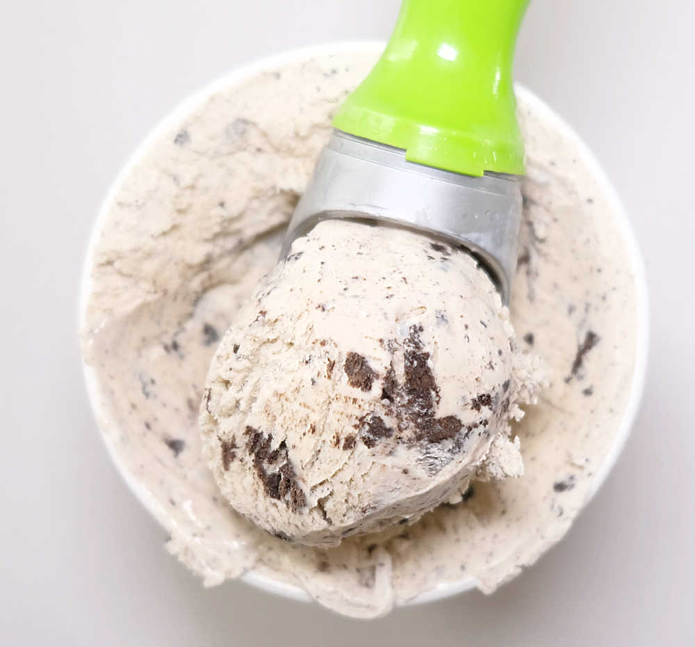 A scoop on the top of an open pack of Cookies and Cream by Indulge.