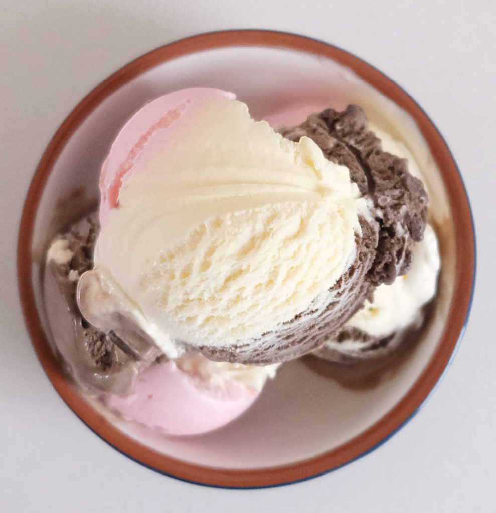 Bird's eye bowl of vanilla, chocolate, and strawberry ice cream.