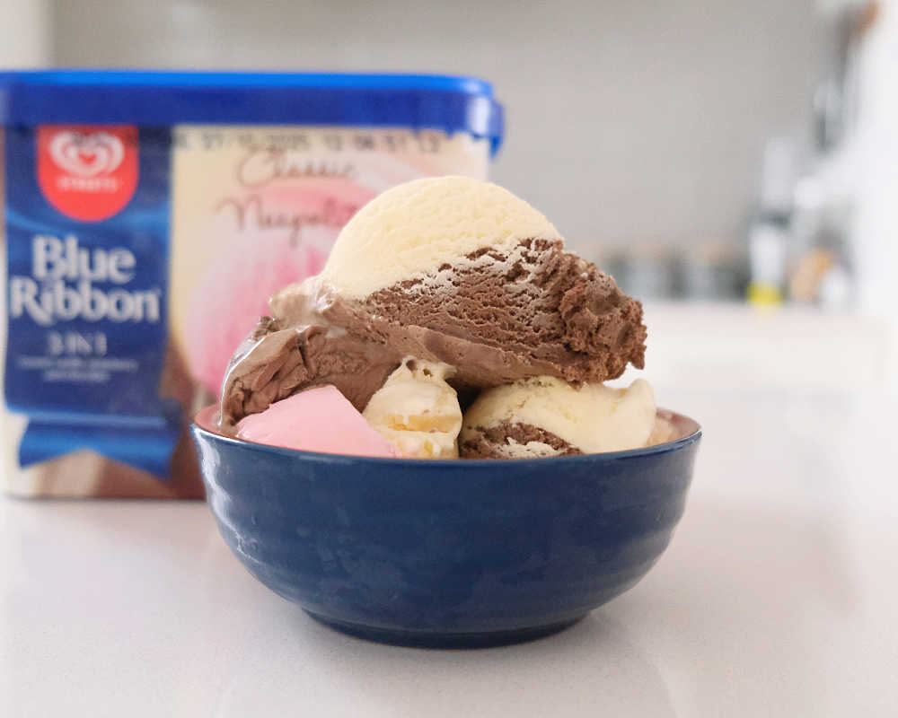 A bowl of Streets Blue Ribbon Neapolitan Ice Cream.