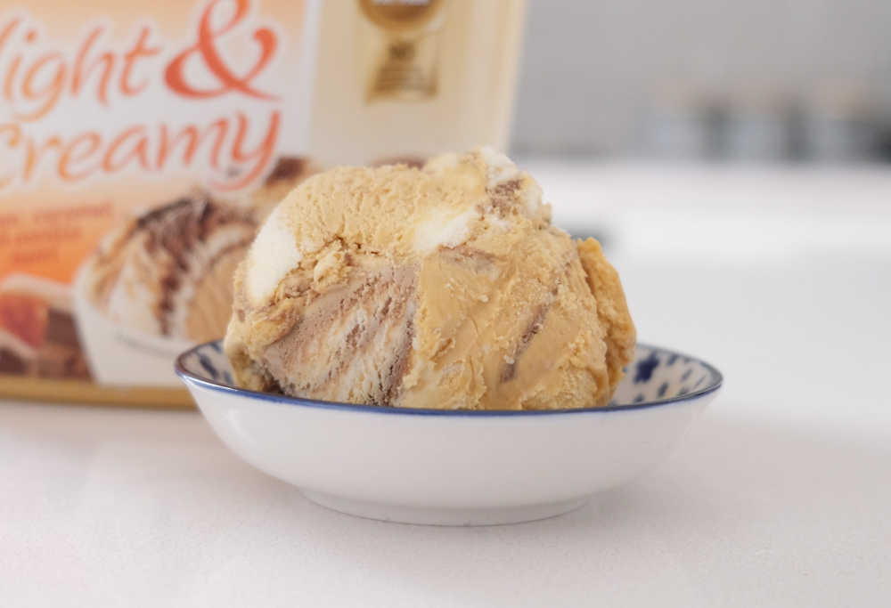 A bowl of Peters L&C Choc, Caramel and Vanilla Ice Cream with the packaging behind it.