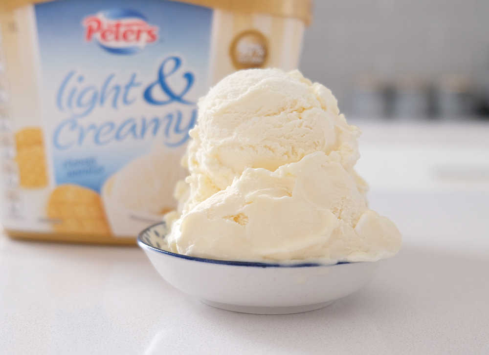 A bowl of Classic Vanilla Ice Cream with the packaging in the background.