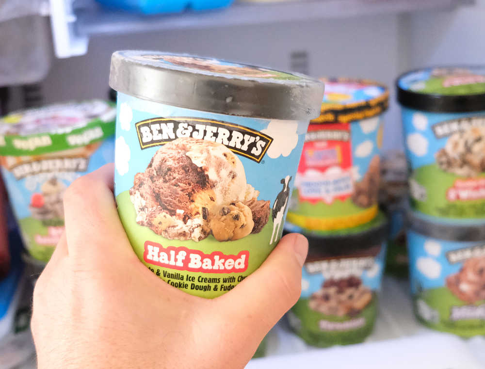 Holding a container of Ben and Jerry's Half Baked in front of a home freezer.