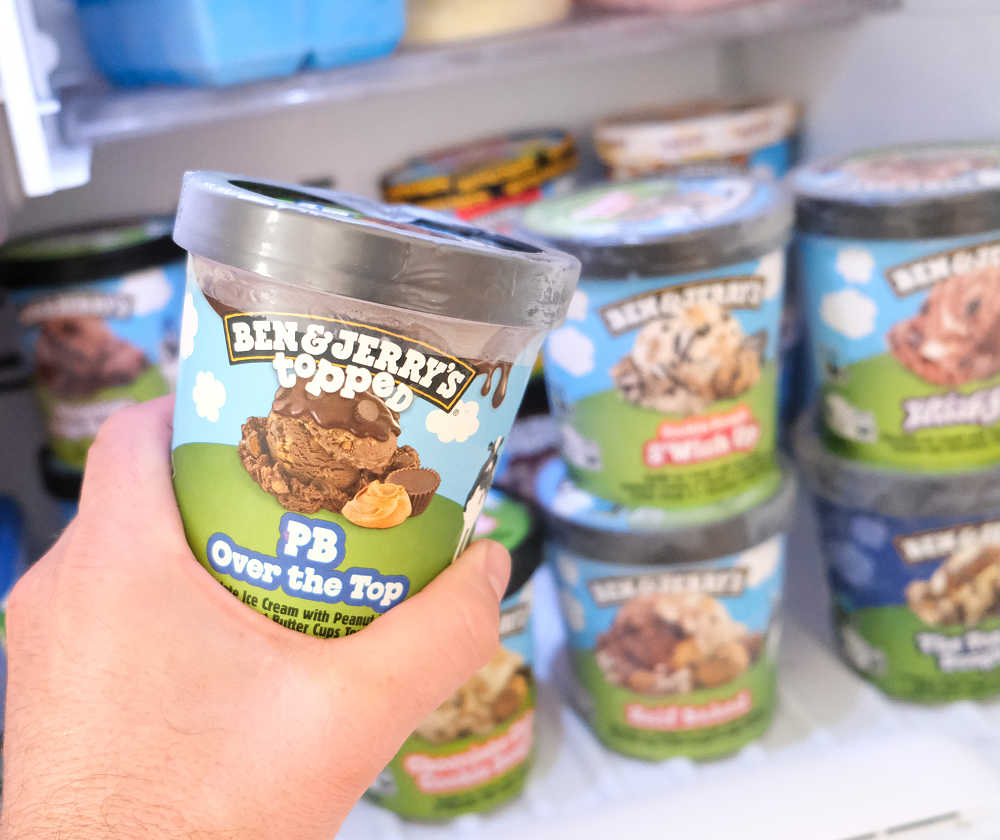 Holding a pack of Ben & Jerry's Topped PB Over the Top Ice Cream.