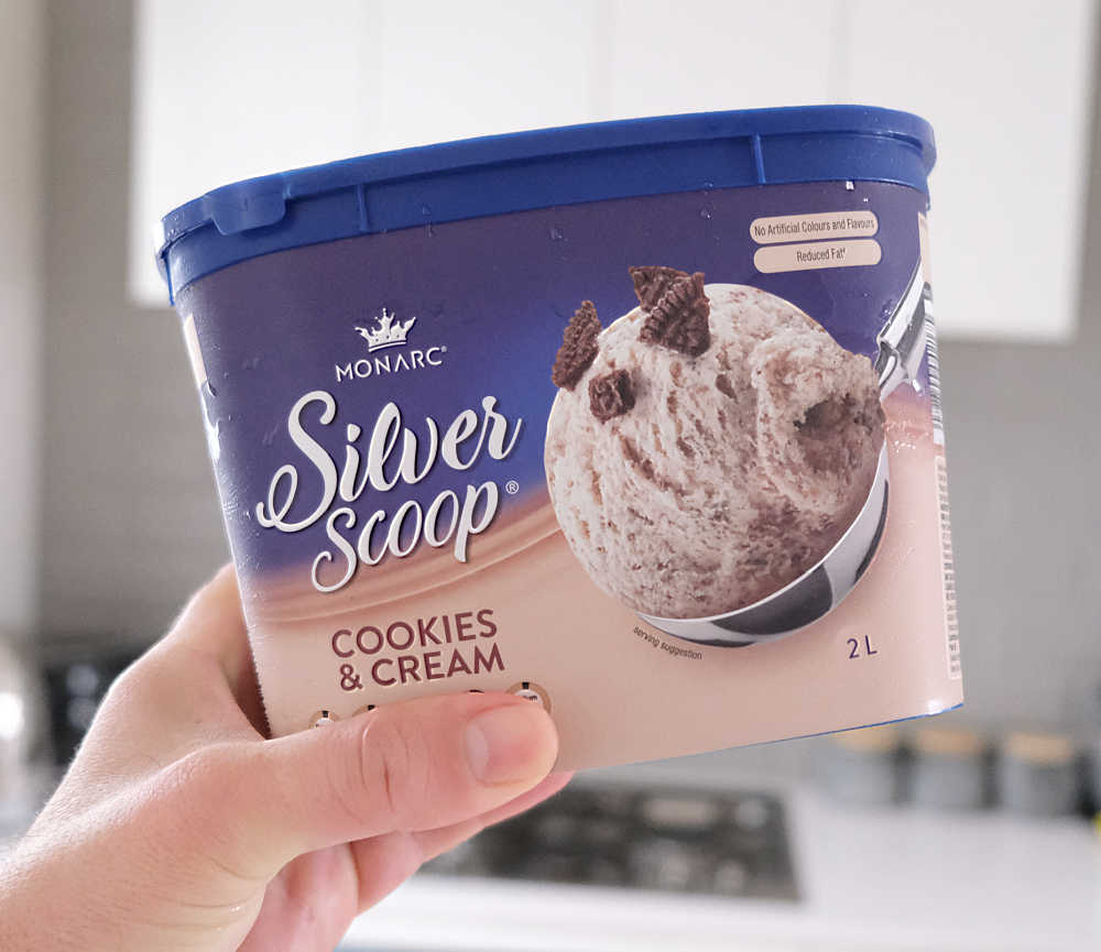 Holding a pack of Cookies and Cream Ice Cream 2L by Silver Scoop.