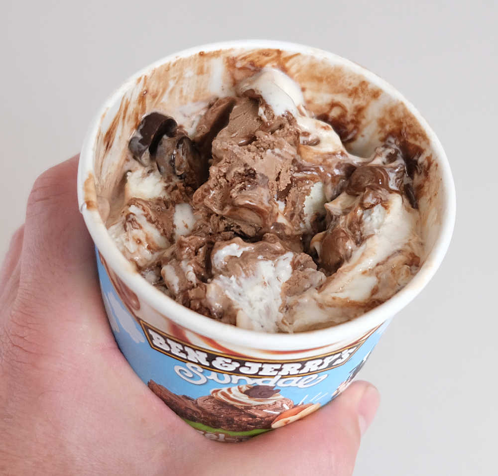 Holding a partly eaten pint of Ben & Jerry's Hazel-nuttin' but Chocolate Ice Cream.