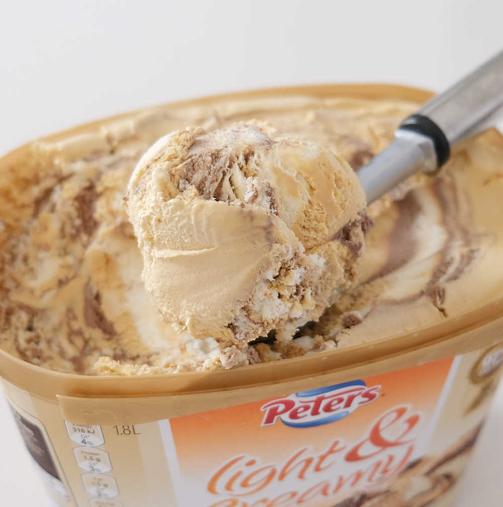 Closeup photo of a scoop of Peters Light and Creamy Choc, Caramel and Vanilla Swirl Frozen Dessert.