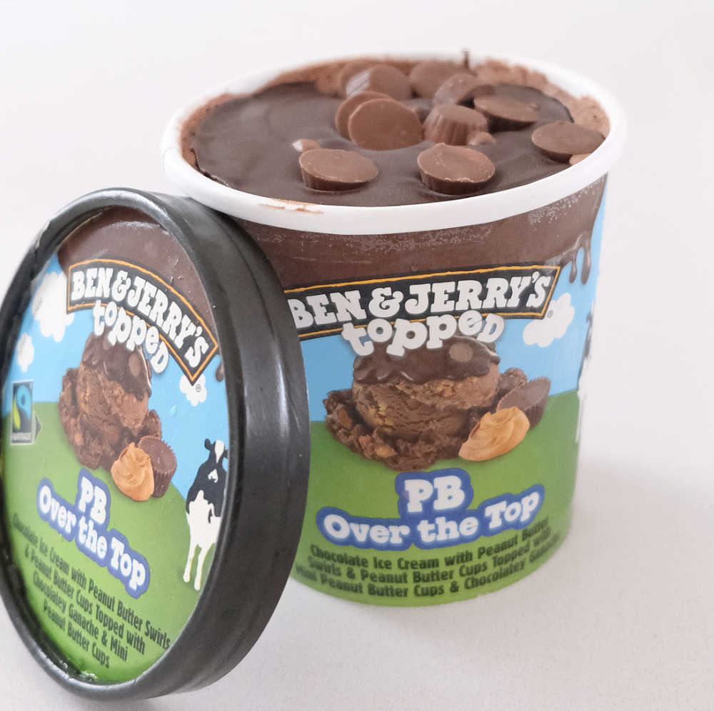 An unscooped container of Ben & Jerry's Topped PB Over the Top Ice Cream with the lid off.