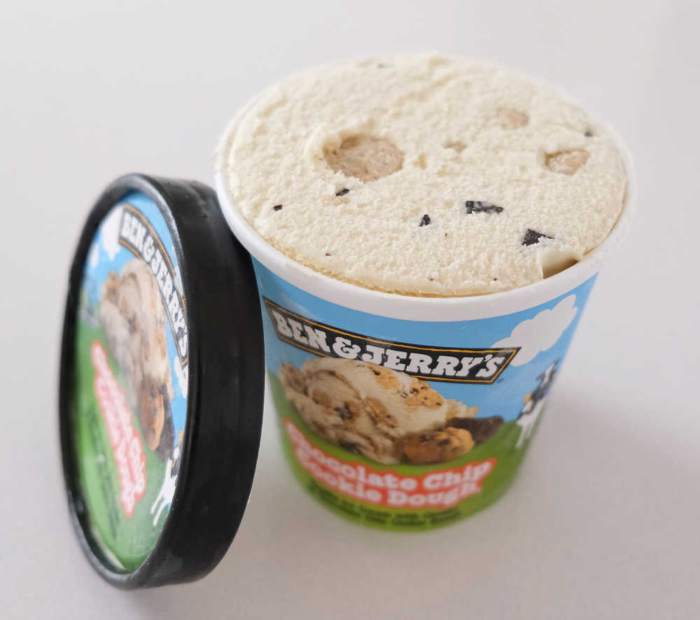 An unscooped pack of Chocolate Chip Cookie Dough Ice Cream with the lid resting on the side.