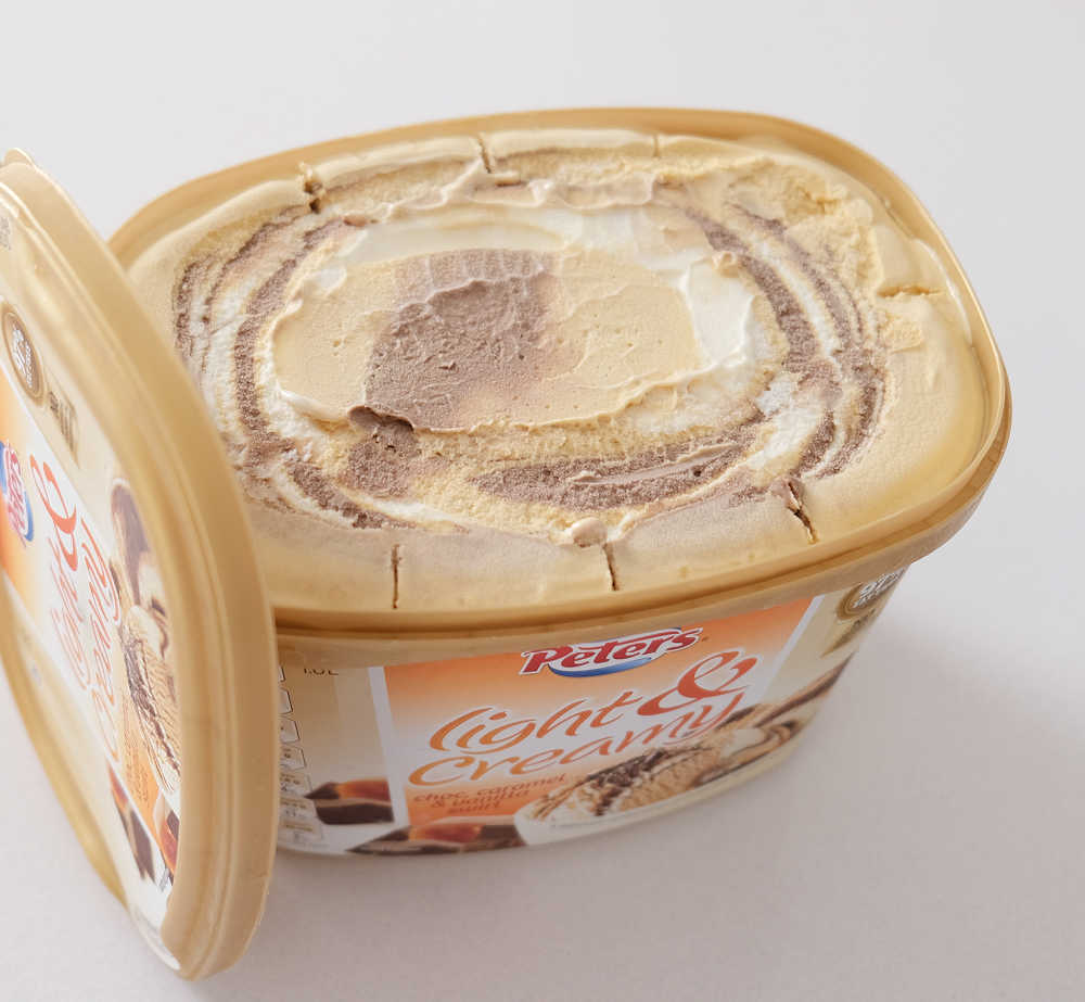 An open pack of Peters Light and Creamy Choc, Caramel and Vanilla Swirl ready to scoop.