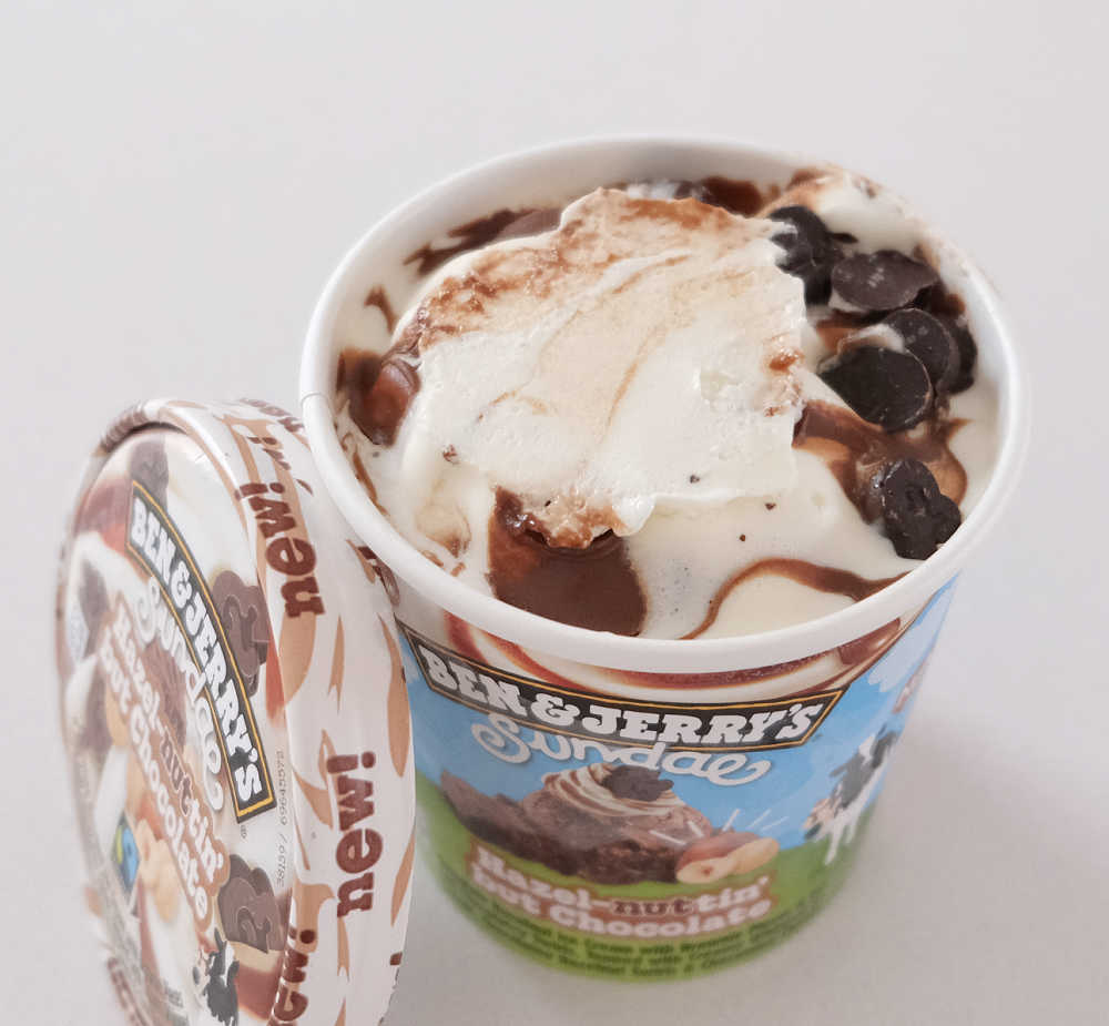 An open pack of Ben and Jerry's Hazel-nuttin' but Chocolate with the lid leaning against the side.