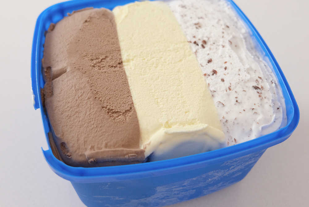 An open tub of Peters Banana Split Frozen Dessert.