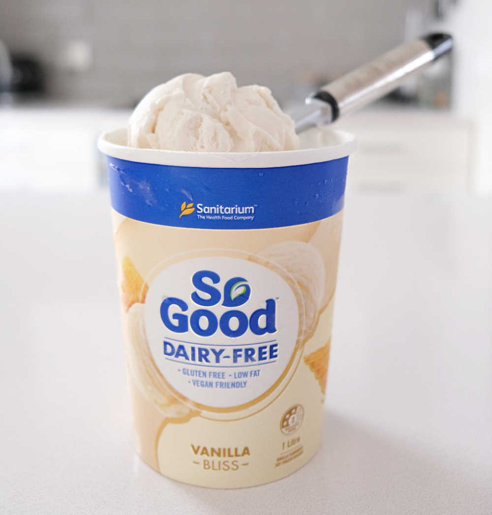 A pack shot of So Good Vanilla Bliss with a scoop on the top of the tub.