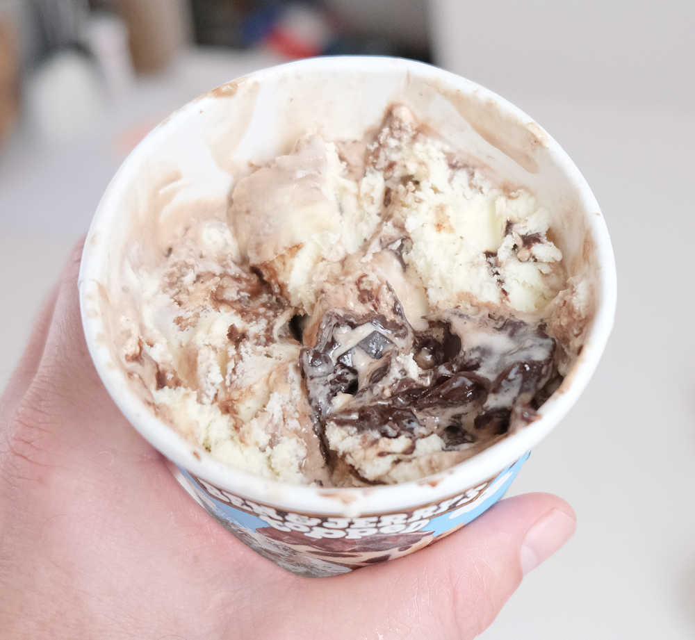 Holding a partly eaten tub of Tiramisu Ice Cream.