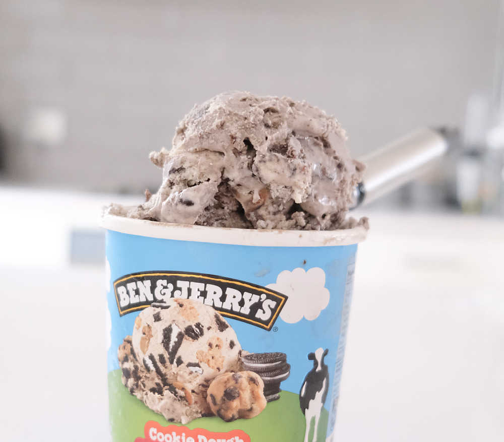 A scoop of Ben and Jerry's Cookie Dough S'Wich Up sitting on the top of the container.