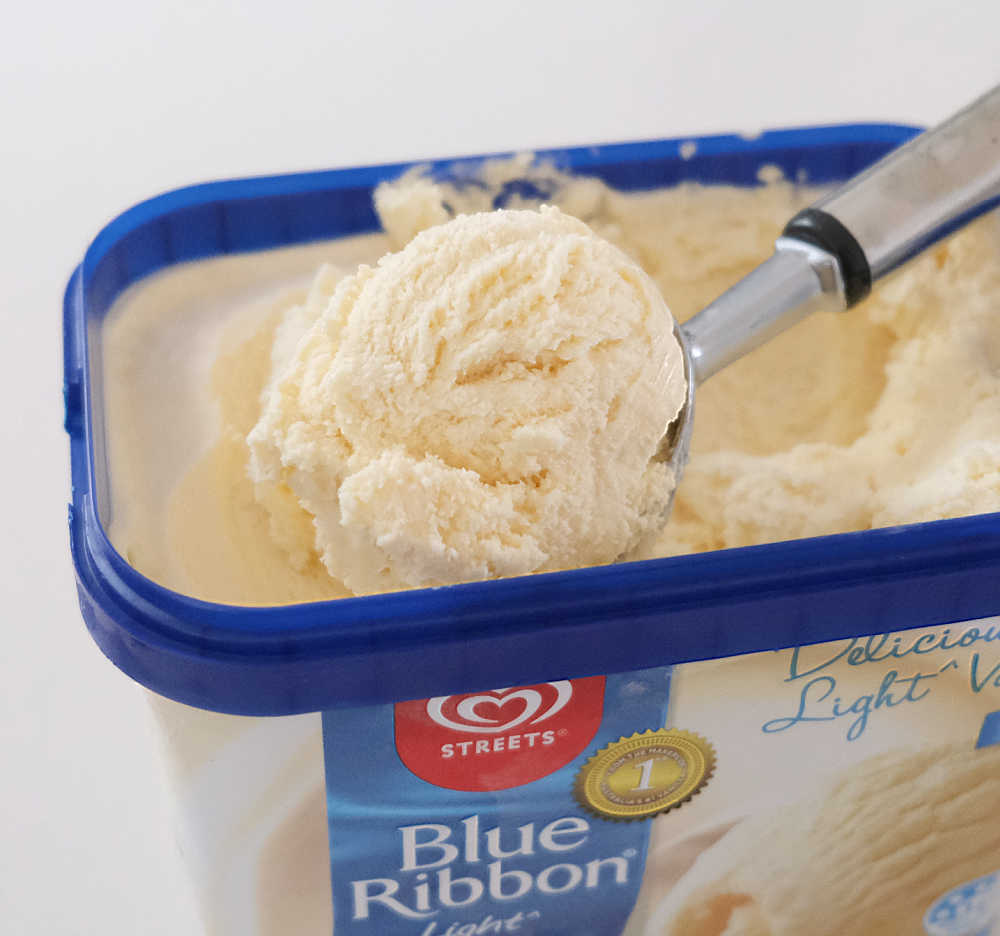 A scoop of RF Vanilla Ice Cream lying on the top of the Blue Ribbon tub.