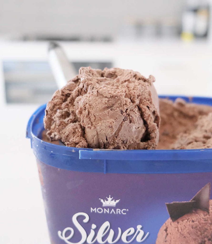 Partly eaten pack of Monarc Silver Scoop Choc Chip Ice Cream with the scoop on the top.
