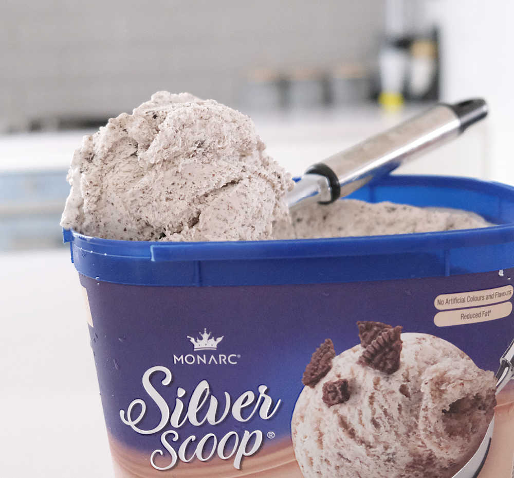 A scoop of Silver Scoop Cookies & Cream resting on the top of the pack.