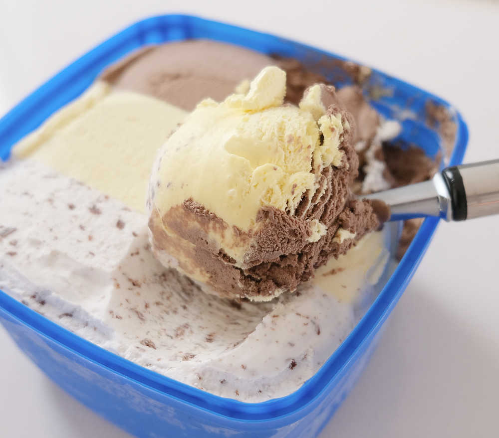 A scoop of Banana Split ice cream resting on the top of the pack.