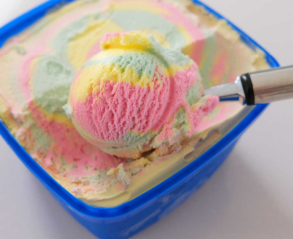 Closeup of a scoop of Peters Original Rainbow showing the bright pink, yellow, and green colours.