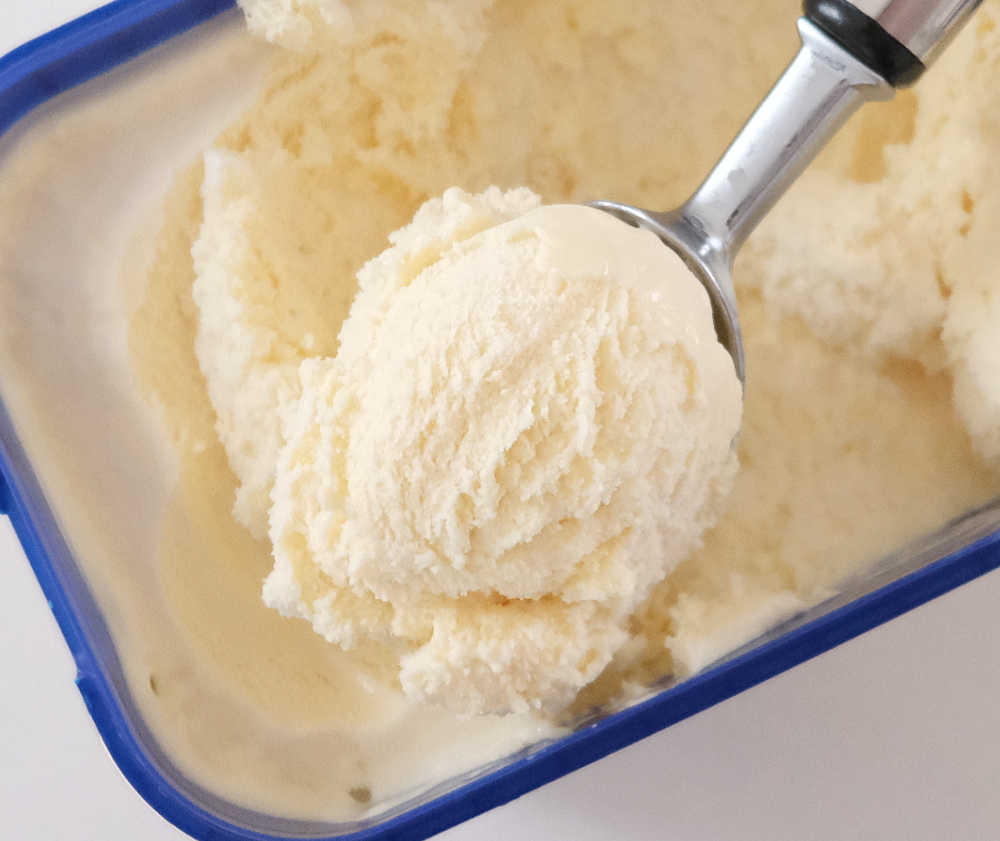 Top down image of a a scoop of Streets Blue Ribbon Light Vanilla Ice Cream resting on the pack.