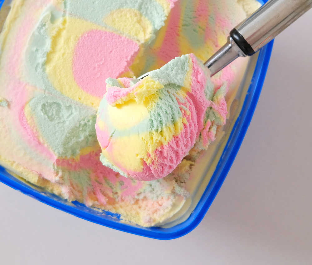 Top down photo of a scoop of Peters Original Rainbow Ice Cream resting on the top of the tub.