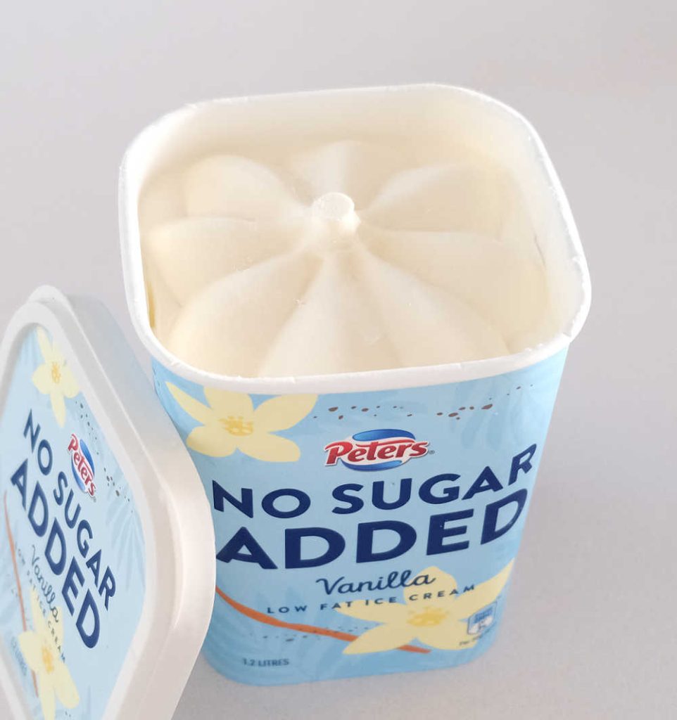 An unscooped container of Peters NSA Vanilla with the lid resting on the side.