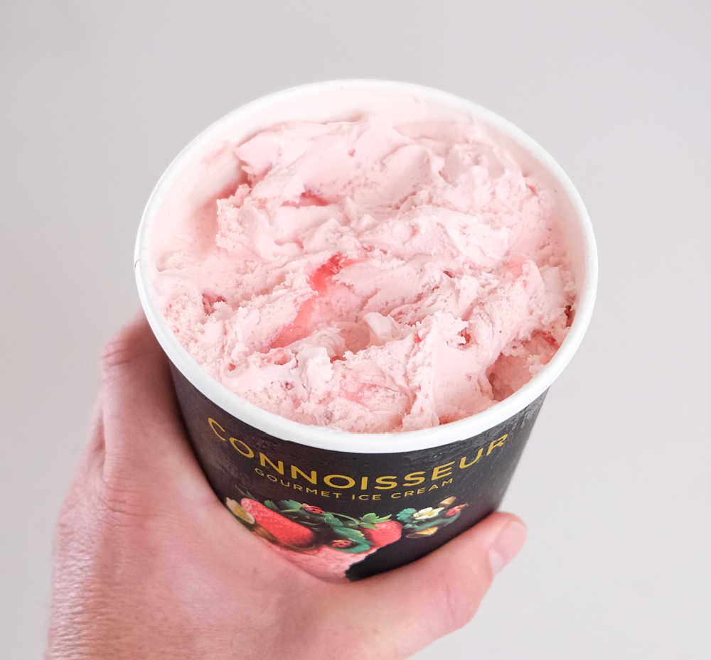 Holding a container of Connoisseur Camarosa Strawberry 1L.