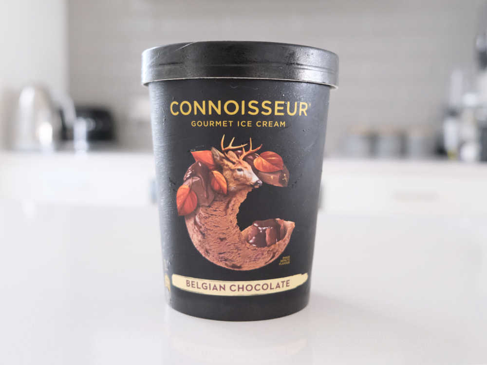 A tub of Connoisseur Gourmet Ice Cream Belgian Chocolate 1L on a kitchen bench.