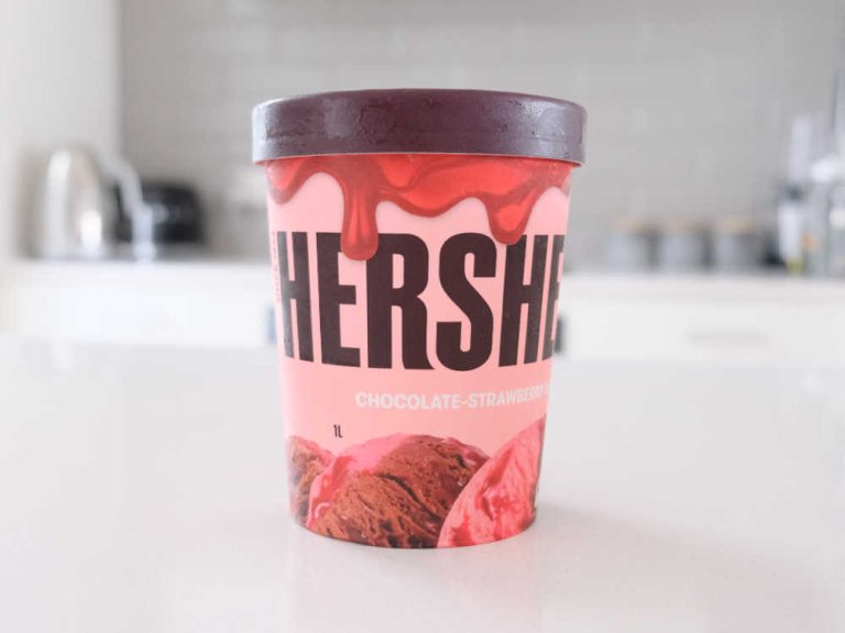 A tub of Hershey's Chocolate-Strawberry Ripple 1L on a kitchen bench.