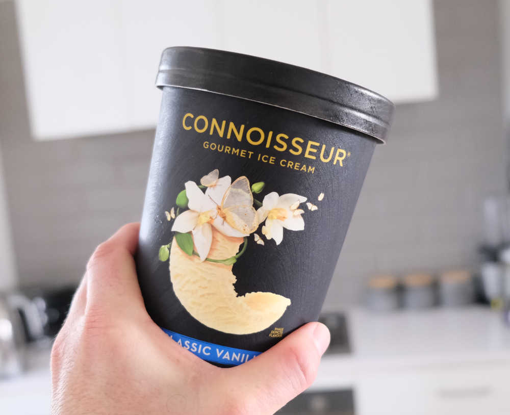 Holding a pack of Connoisseur Classic Vanilla Ice Cream.