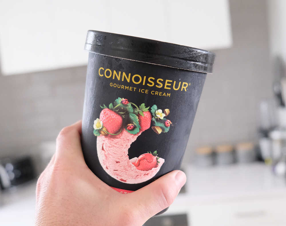 Holding a pack of Connoisseur Gourmet Ice Cream Camarosa Strawberry.