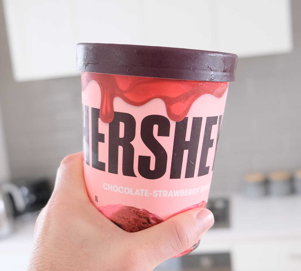 Holding a pack of Hershey's Chocolate-Strawberry Ripple Frozen Dessert.