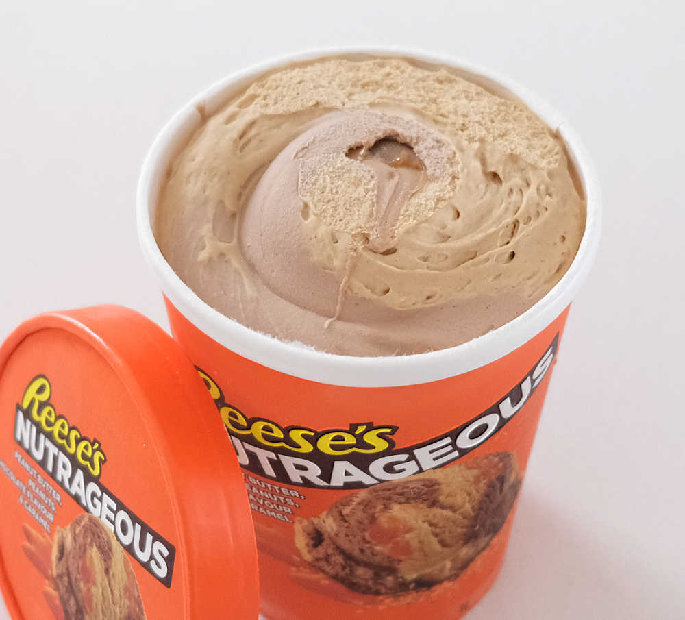 An open container of Reese's Nutrageous with the lid leaning against the side.