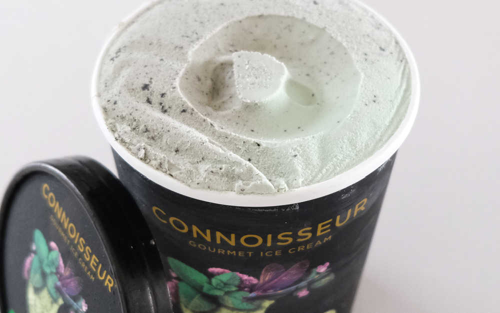 An unscooped pack of Connoisseur Ice Cream Mint & Cookies with the lid leaning against the side.