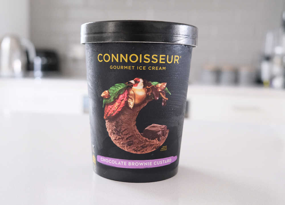 A tub of Connoisseur Gourmet Ice Cream Chocolate Brownie Custard on a kitchen bench.
