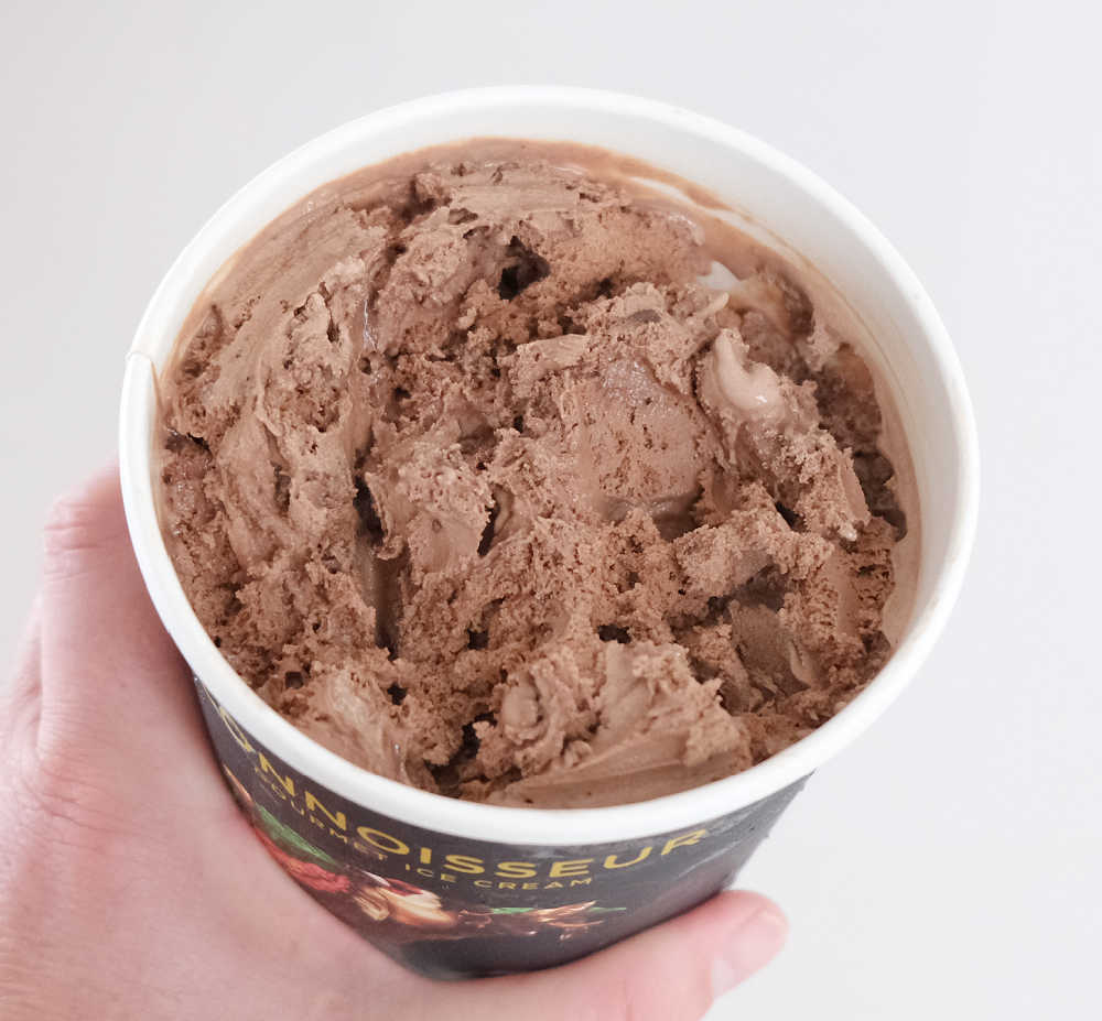 Holding a partly eaten pack of Chocolate Brownie Custard by Connoisseur.