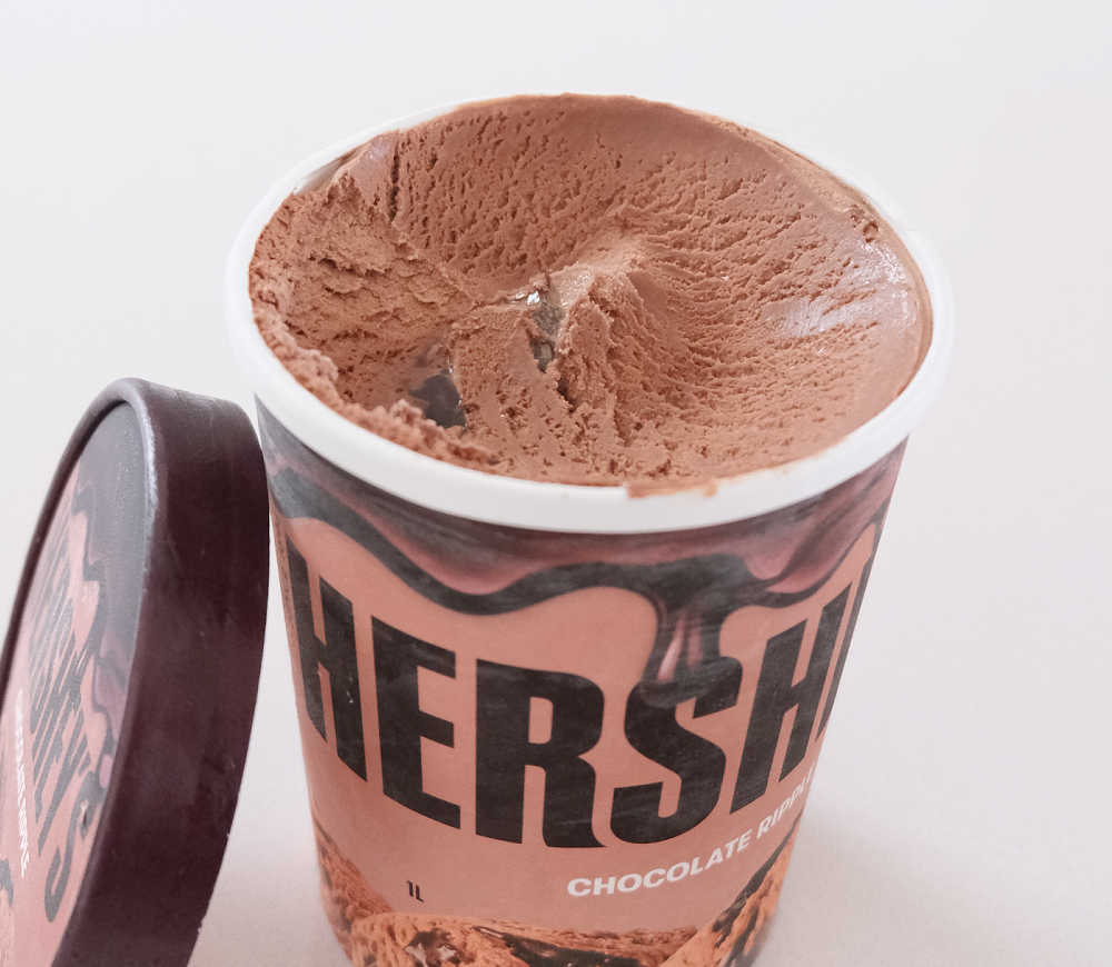 A partly eaten tub of Hershey's Chocolate Ripple Ice Cream.