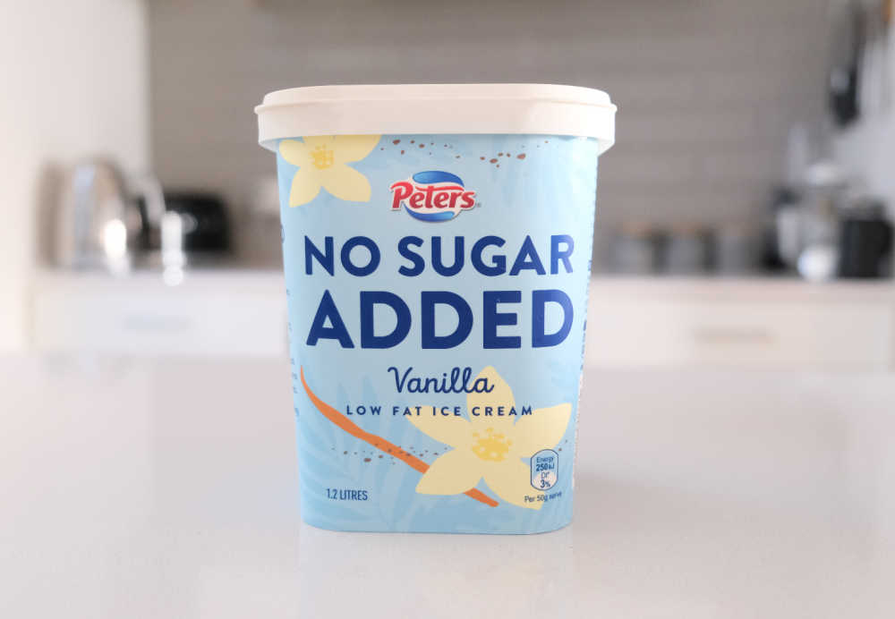 A tub of Peters No Added Sugar Vanilla Ice Cream sitting on a kitchen bench.