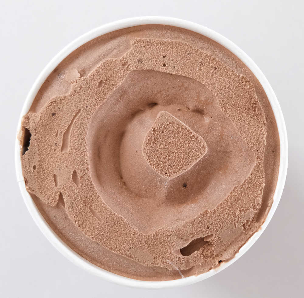 An unscooped tub of Choc Brownie Custard Ice Cream.